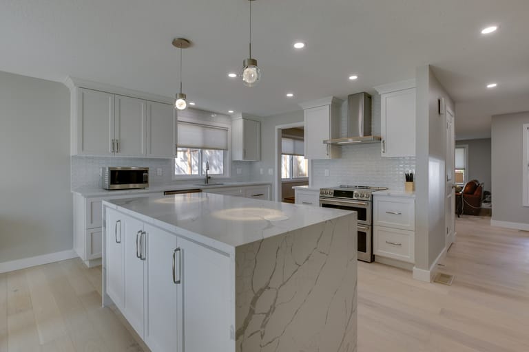 Spacious kitchen with central island, stainless steel appliances, and marble countertops