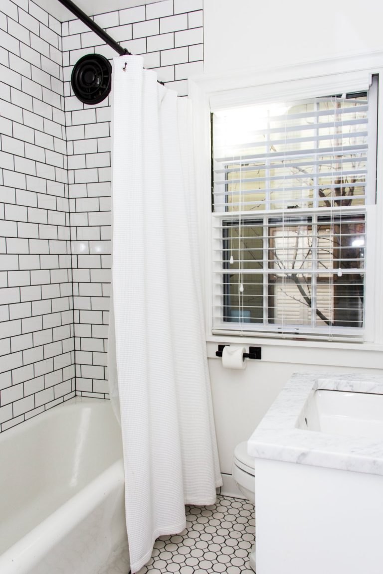 Bathroom shower with dark grout and white subway tile