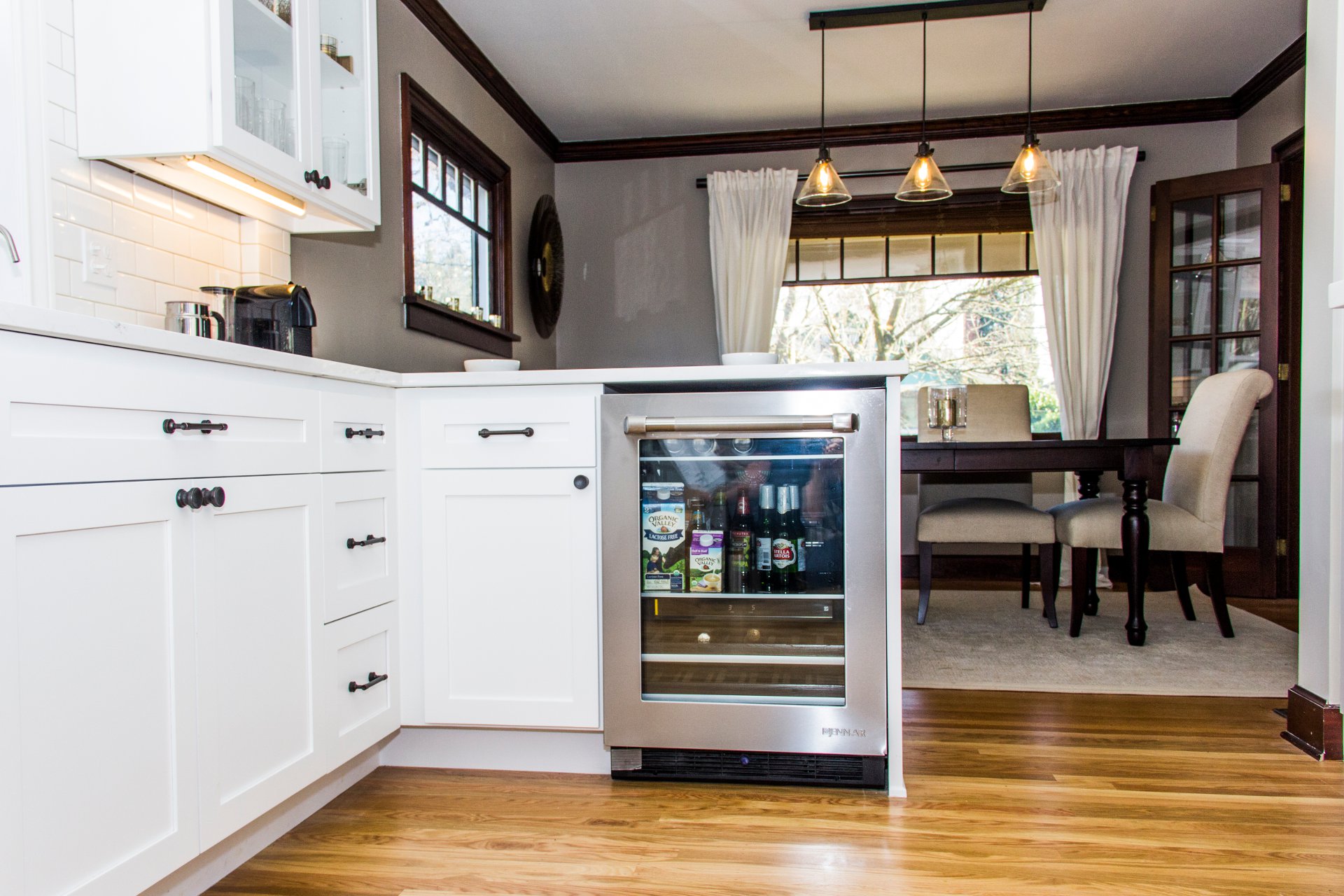 White kitchen cabinets and a custom wine cooler