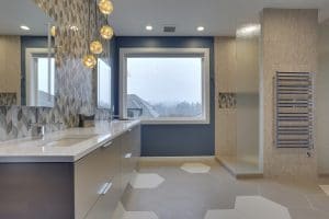 modern bathroom with warm color palette. hanging vanity lights, large window